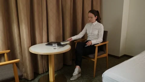 Woman lay aside small notepad and pick up phone, sit resting at chair Stock Footage 131195242