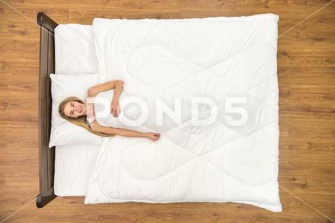 The woman lay on the bed and smile. View from above Stock Photos