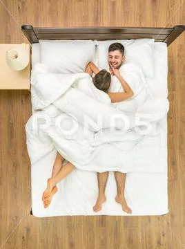 The woman lay near a man on the bed. View from above Stock Photos