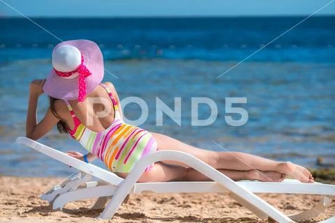 The woman lay on the sunbed on the sea background Stock Photos
