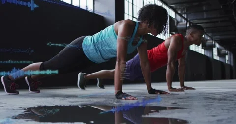 Woman leading man doing sync pushups on wet floor HUD waves growing over Stock Footage 329870843