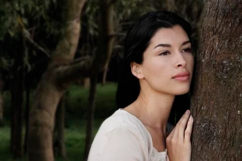 Woman leaning against tree Stock Photos