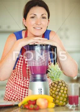 Woman Leaning Face On Mixer In Kitchen