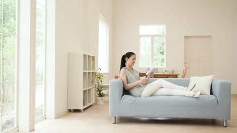 A Woman Leaning on a Sofa Vídeos de archivo 332775682