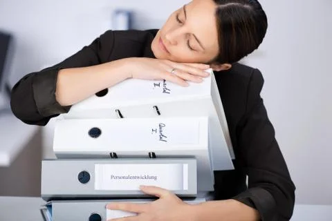 Woman leaning on stack of binders Foto stock