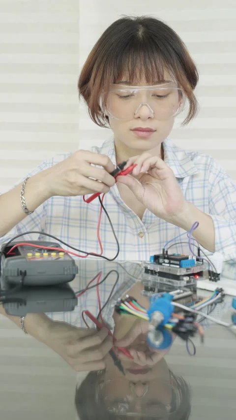 Woman is learning about and experimenting with the operation of a microcontrolle Stock Footage 334764555