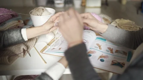 Woman learning to knit using book with knitting pattern. Knitting hands Stock Footage 87063133