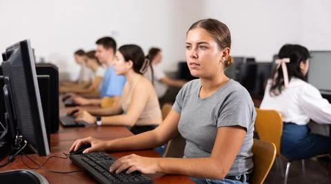 Woman learning to use software in computer class Stock Photos