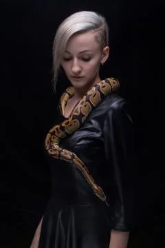 Woman in leather dress with python Stock Photos