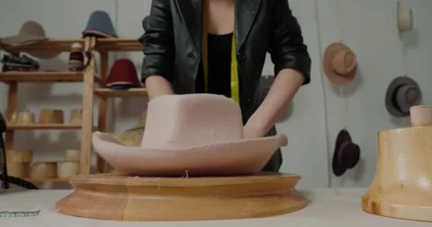 Woman in leather jacket makes shape of handmade felt hat Stock Footage 207454313