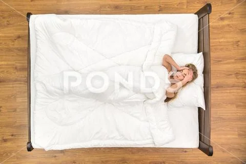 The woman lie on the bed. View from above Stock Photos