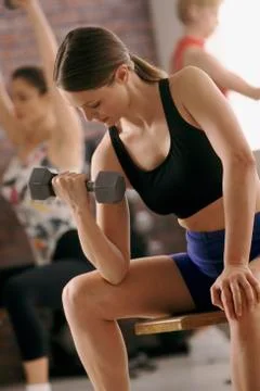 Woman lifting free weight at gym Stock Photos