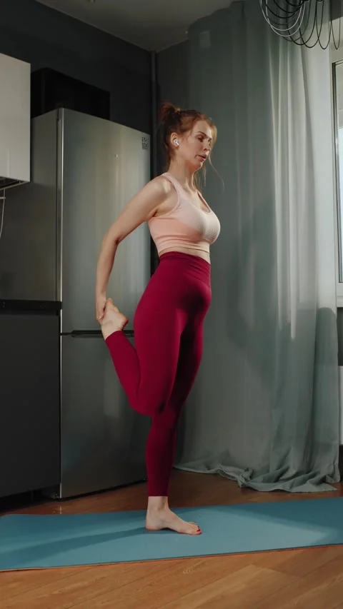 Woman lifting knee while exercising on yoga mat at home Vídeos de archivo 319442832
