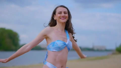 A woman in a light blue, patterned bikini strolls and relaxes on the beach Video stock 308514163