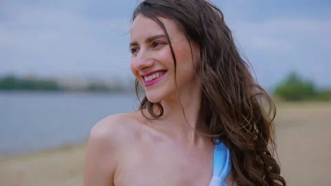 A woman in a light blue, patterned bikini strolls and relaxes on the beach Video stock 308514548