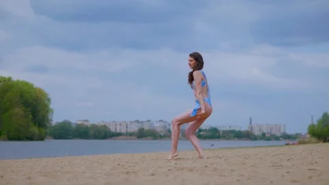 A woman in a light blue, patterned bikini strolls and relaxes on the beach Video stock 308514585