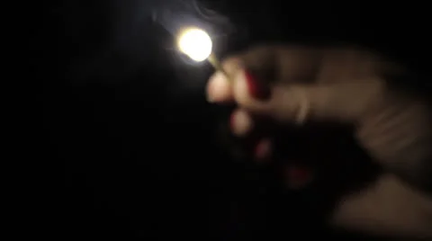 Woman lighting a match in the dark Stock Footage
