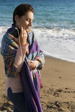 Woman listening to music walking on the beach Stock Photos