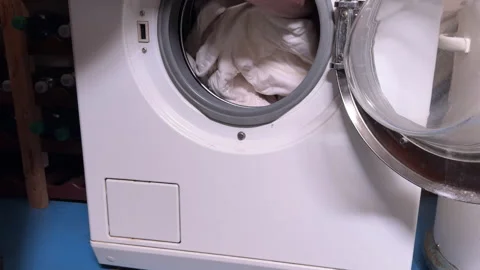 Woman Loading Bedding Into Front Load Washing Machine Stock Footage 345361578
