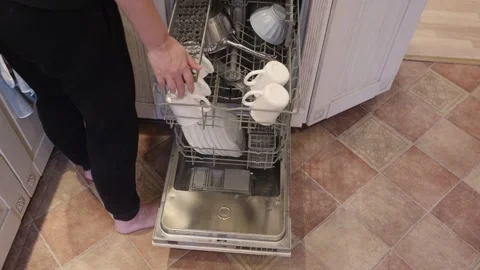 Woman loading kitchenware into dishwasher Stock Footage 326577600