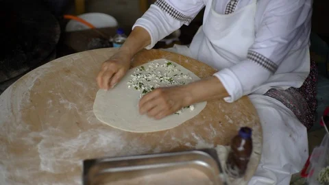 A woman is loading stuffing into a pancake, cheese, meat, potatoes. Wraps Video stock 91015369