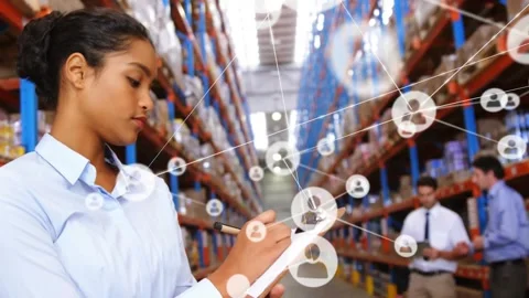 Woman logging inventory, team tapping tablet causing network overlay showing ops Stock Footage 330258367