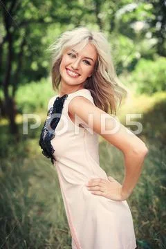 Woman with long blond hair posing in summer park Stock Photos