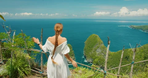 Woman with long braid enjoys the view of Kelingking Beach in Bali Nusa Penida Stock Footage 345689638