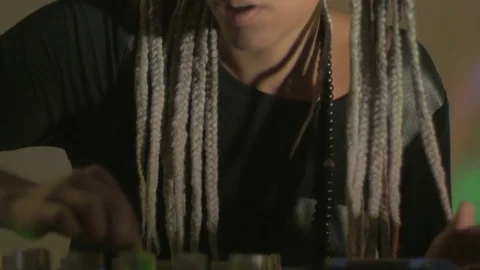 A woman with long braids adjusts knobs on her mixing board 스톡 동영상 72081939