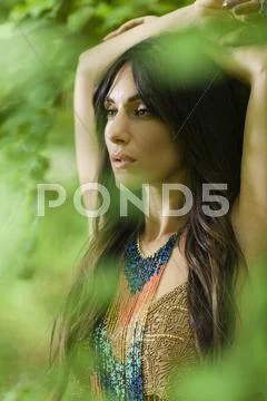 A woman with long brown hair outdoors in woodland. Stock Photos