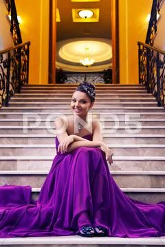 Woman in a long dress sitting on the stairs Stock Photos