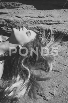 Woman with long hair, hairstyle relax on sand Stock Photos