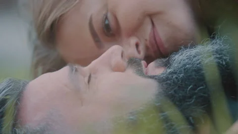 Woman looking affectionately at a man while lying down outdoors Stock Footage 275268488