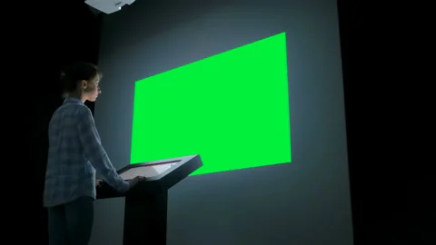 Woman looking at blank large interactive wall display - green screen concept Video stock 111521342
