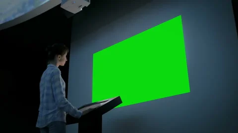 Woman looking at blank large interactive wall display - green screen concept Video stock 112088548