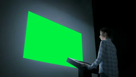 Woman looking at blank large interactive wall display - green screen concept Video stock 115348535