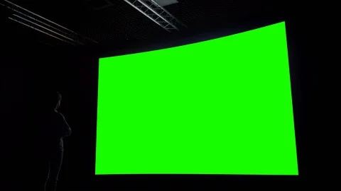 Woman looking at blank large interactive wall display - green screen concept Video stock 128687316