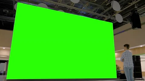 Woman looking at blank large interactive wall display - green screen concept Video stock 142021310