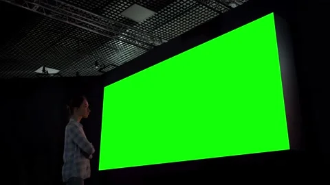 Woman looking at blank large interactive wall display - green screen concept Video stock 142021787