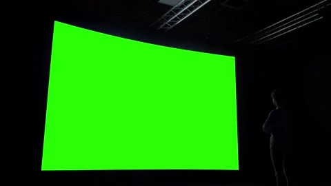 Woman looking at blank large interactive wall display - green screen concept Video stock 146367501