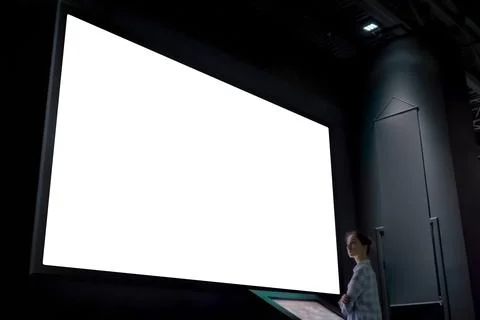 Woman looking at blank large interactive wall display - white screen concept Stock Photos
