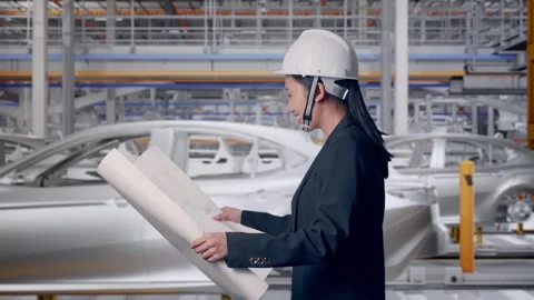 Woman Looking At Blueprint While Walking In Car Factory Stock Footage 331631367