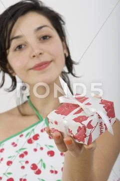 Woman looking at camera and holding present Stock Photos