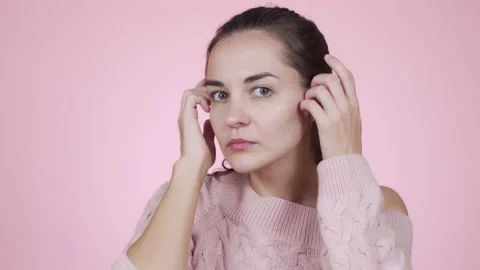 Woman looking at camera like mirror fixing her hair isolated on pink background Video stock 131230963