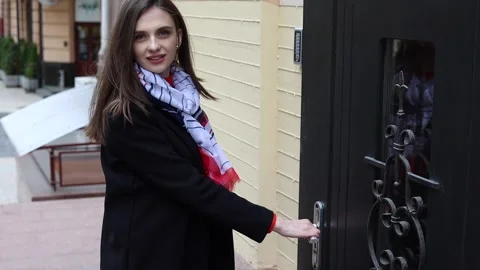 Woman looking at the camera, opening the front door. Stock Footage 238028675