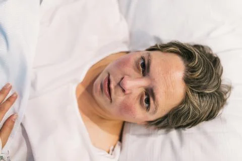 Woman looking at the camera while lying on a hospital stretcher. Stock Photos