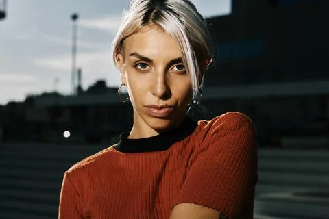 Woman looking at the camera while posing with her face lit outdoors. Stock Photos