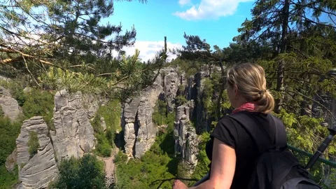 Woman looking down a cliff Stock Footage 75419481