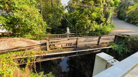 Woman looking down from an old bridge Stock Footage 233376043