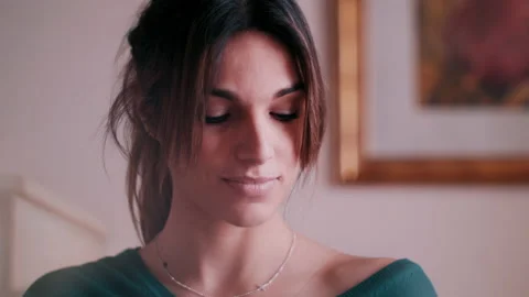 Woman looking down with a tiny grin on her face Video stock 131184898